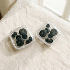 Two clear cases of earplugs and ear tips side by side on a white bed